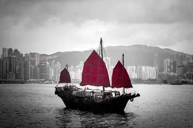 Historic red-sail junk boat gliding through Hong Kong’s Victoria Harbour