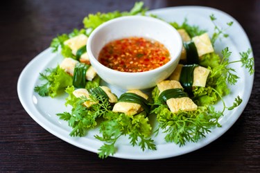 Thai miang kham appetizer—herb leaves with bite-size coconut and ginger wraps served with a spicy chili dipping sauce.