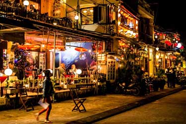 Lantern-lit street with lively cafés and restaurants in Hoi An, Vietnam, capturing the town’s romantic evening atmosphere and well-preserved historic charm.