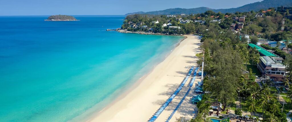 Rows of lounge chairs lined a long a pristine coastline of Katathani Phuket beach.