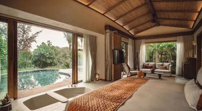 Private pool villa at Namia River Retreat featuring open-plan design, floor-to-ceiling windows, and tranquil garden views, offering a refined luxury retreat near the cultural charm of Hoi An.