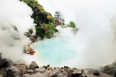 Steaming turquoise hot spring pools nestled in misty mountains, the serene geothermal landscape of Kinosaki onsen