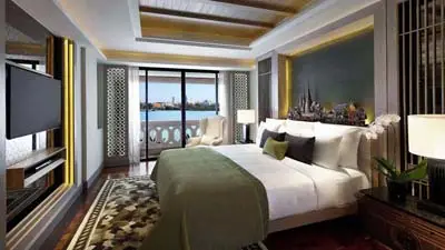 Guest room at Anantara Riverside Bangkok Resort overlooking the Chao Phraya River, featuring elegant Thai-inspired décor, a plush king bed, and a private balcony with water views.