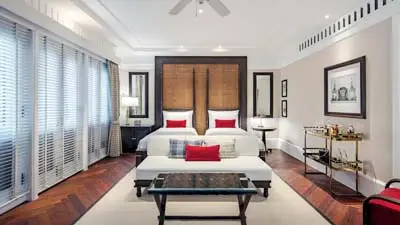 Elegant suite at 137 Pillars House Chiang Mai, featuring colonial-inspired design, a plush king bed, rich wood floors, and refined décor in a tranquil boutique setting.