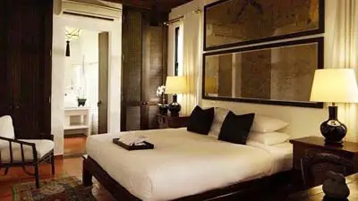 Guest room at Rachamankha Hotel Chiang Mai, featuring minimalist design, warm wood furnishings, and a serene atmosphere within the Old City, conveniently located near historic temples and cultural landmarks.
