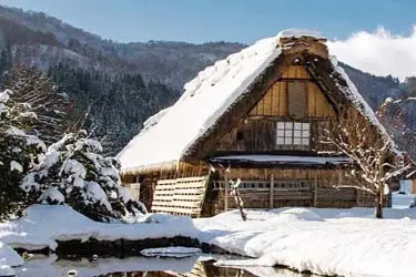 Snow-covered gassho-zukuri farmhouse in Shirakami-go, a UNESCO World Heritage village in rural Japan during winter.