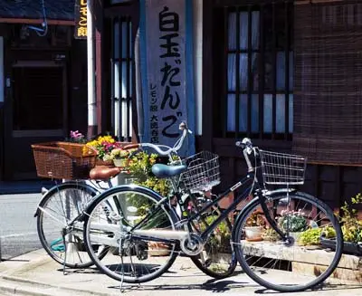 In Kyoto's quiet lanes, bicycles suggest the pace of local living—unhurried movement through preserved wooden neighborhoods