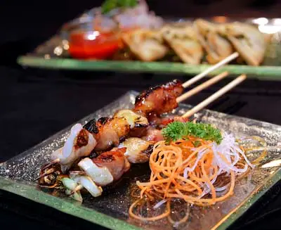 Yakitori grilled chicken skewers with crispy glaze and fresh condiments, an authentic Japanese street food experience