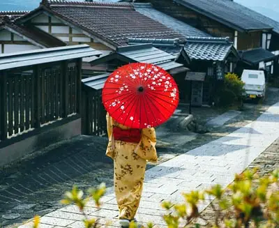 Woman carrying red traditional Japanese umbrella in Kyoto, Gion District Kyoto