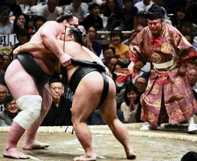Sumo wrestlers locked in competition within the traditional ring, embodying Japan's ancient martial tradition
