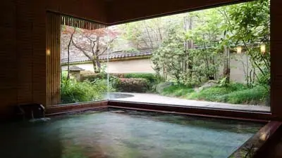 At Ryokan Nishimuraya Honkan in Kinosaki-onsen, a private bath frames the garden view—where thermal waters meet architectural precision
