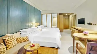 Spacious guest room at Dusit Thani Krabi Beach Resort, featuring contemporary Thai décor, twin beds, warm wood accents, and a bright, airy beachfront retreat atmosphere.
