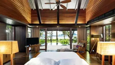 Oceanfront guest room at The Tubkaak Boutique Resort Krabi, featuring natural wood design, a plush king bed, and direct views toward the Andaman Sea in a tranquil beachfront setting.