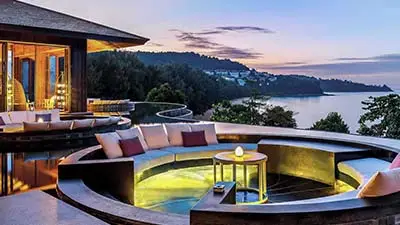 Infinity-edge lounge and plunge pool at Pullman Phuket Arcadia Naithon Beach, overlooking the Andaman Sea at sunset in a tranquil clifftop setting.