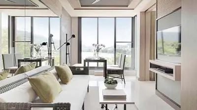 Modern guest room at Amari Phuket, featuring a bright open-plan layout, contemporary furnishings, and large windows with views toward the Andaman Sea, conveniently located near Patong Beach.