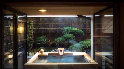 Ryokan Hidatei Hanaougi's private onsen pavilion framing a precisely pruned garden, where silence deepens the luxury experience