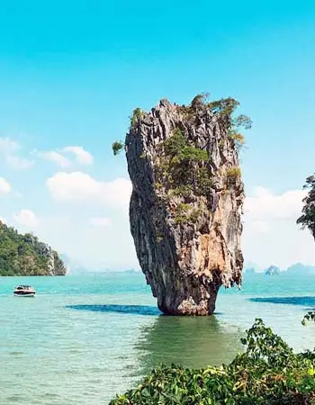 Ko Tapu (James Bond Island) limestone karst rising from turquoise waters in Phang Nga Bay, Thailand, surrounded by tropical seascape and distant islands.