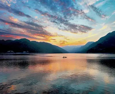 Sunset over the Yangtze River with calm waters and mountain silhouettes, highlighting one of China’s most scenic waterways.