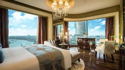Opulent guest room at The Reverie Saigon featuring floor-to-ceiling windows, lavish Italian design, and panoramic views of Ho Chi Minh City for an ultra-luxury urban stay.