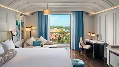 Elegant guest room at Hotel Royal Hoi An, featuring refined interiors, river-view windows, and walkable to Hoi An Ancient Town.
