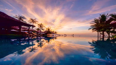 Sunset over the beachfront infinity pool at The Anam Cam Ranh, Vietnam, showcasing elegant seaside luxury and sweeping views of the South China Sea.