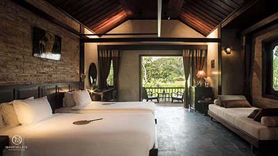 Spacious guest room at Nham Village Resort in Vietnam featuring rustic elegance, natural materials, and tranquil views, offering a peaceful retreat immersed in the surrounding countryside.