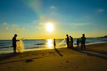 Fishermen casting nets at sunset on Phu Quoc Island, Vietnam, capturing the island’s coastal beauty and traditional seaside livelihoods.