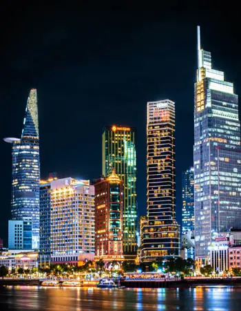 Ho Chi Minh City skyline illuminated at night along the Saigon River, showcasing Vietnam’s dynamic urban energy and modern architectural landmarks.