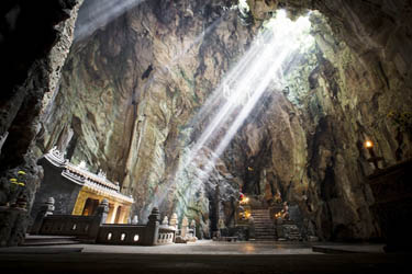 Sunlight streaming into Huyen Khong Cave at the Marble Mountains in Da Nang, Vietnam, illuminating sacred shrines and highlighting the site’s spiritual ambiance and striking natural formations.