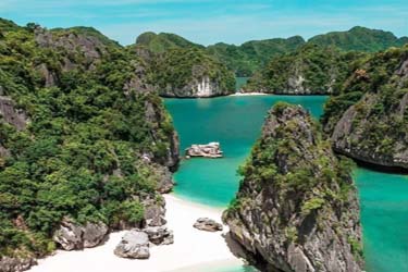 Secluded white-sand beach framed by limestone cliffs in Lan Ha Bay, Vietnam, revealing the region’s hidden coves and pristine natural beauty.