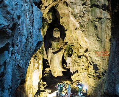 Buddhist statue set within a sacred cave at the Marble Mountains in Da Nang, Vietnam, reflecting the site’s spiritual significance and ancient religious heritage.
