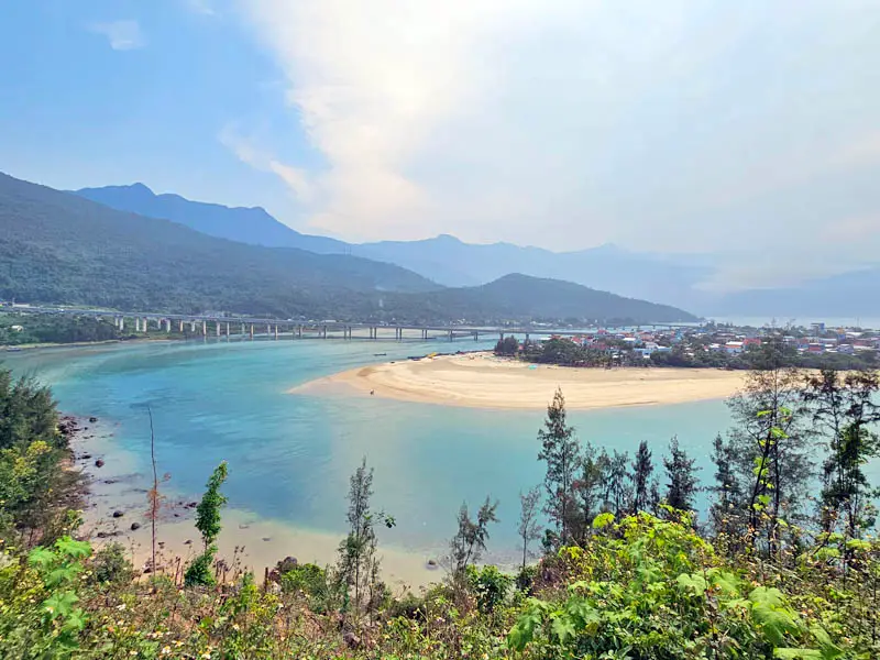 Scenic view of Lăng Cô Bay with turquoise water, sandy peninsula, and Hải Vân Pass mountains near Da Nang, Vietnam