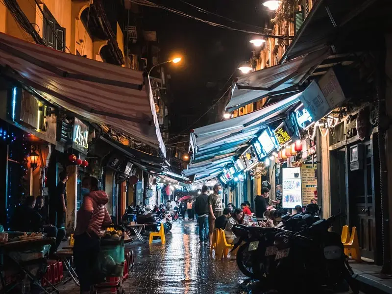 Hanoi Old Quarter nightlife scene with street food stalls, neon lights, and locals dining on Ta Hien Beer Street Vietnam