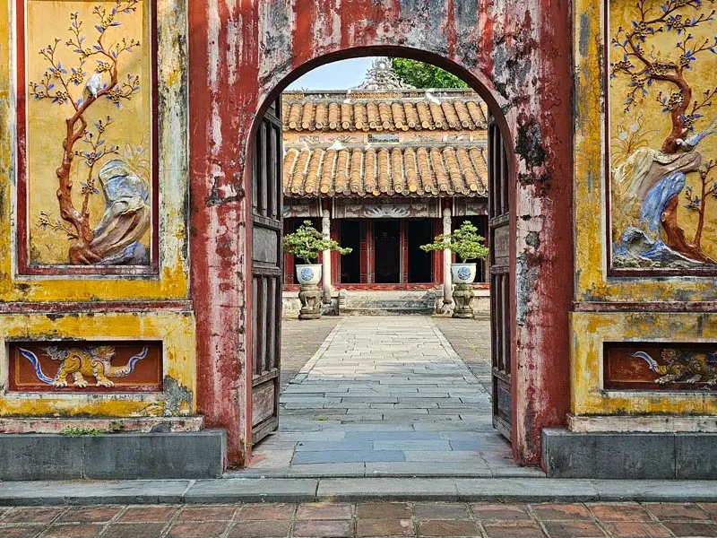 Historic gate and courtyard of the Imperial City in Hue Vietnam with colorful ancient murals and traditional architecture