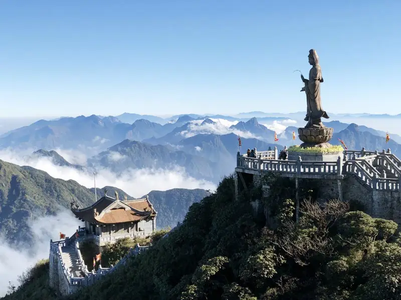 Panoramic view of Fansipan’s mountaintop pagoda and giant Guanyin statue above the clouds in Sapa, Vietnam — a luxury highland travel experience.