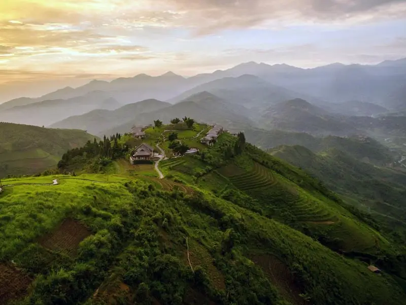 Luxury mountain resort overlooking Sapa’s terraced valleys at sunrise — aerial view of northern Vietnam’s highland escapes.
