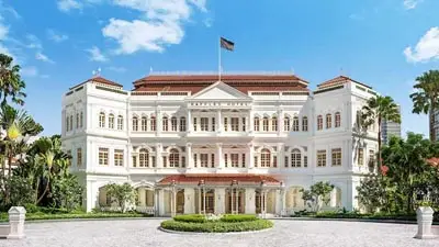 Elegant exterior of Raffles Hotel Singapore, a landmark of colonial-era grandeur surrounded by tropical gardens