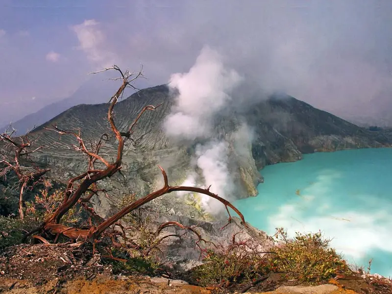 Sulfur steam rising from Kawah Ijen crater above the turquoise volcanic lake, showcasing East Java’s dramatic geothermal landscape near the Bali crossing route