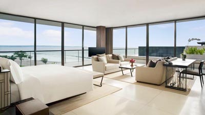 Luxury oceanfront suite at Alila Villas Seminyak featuring floor-to-ceiling glass, open-plan living, and panoramic Indian Ocean views