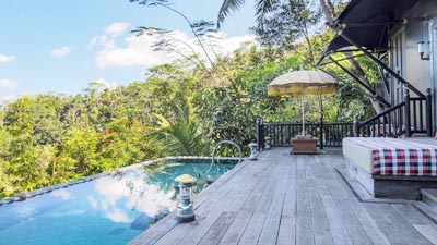 Private tented villa deck and infinity pool at Capella Ubud, Bali, overlooking lush rainforest surroundings for an immersive luxury jungle retreat.