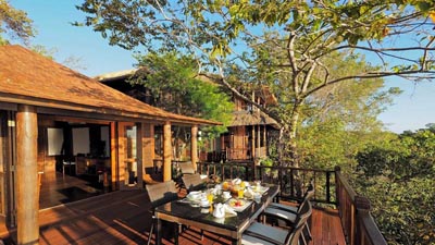 Open-air dining terrace at Menjangan by Lifestyle Retreats in West Bali, overlooking lush tropical forest and coastal landscapes in a secluded villa setting