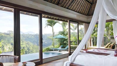 Luxury private villa bedroom at Royal Pita Maha Ubud overlooking jungle-clad river valley with infinity-edge plunge pool and open-air terrace views