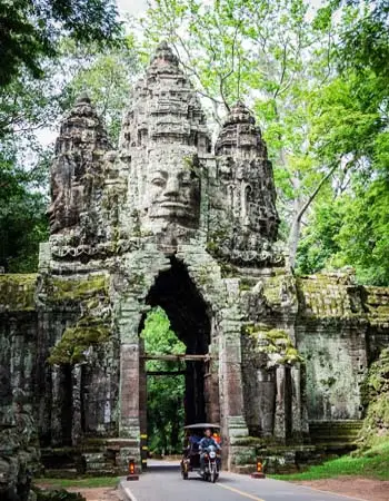 South Gate of Angkor Thom in Cambodia, featuring towering stone faces and ancient Khmer carvings framed by jungle greenery.