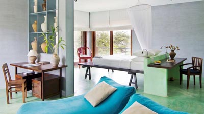 Elegant ocean-view suite at Knai Bang Chatt Resort Kep featuring minimalist design, private sitting area, and coastal light-filled interiors