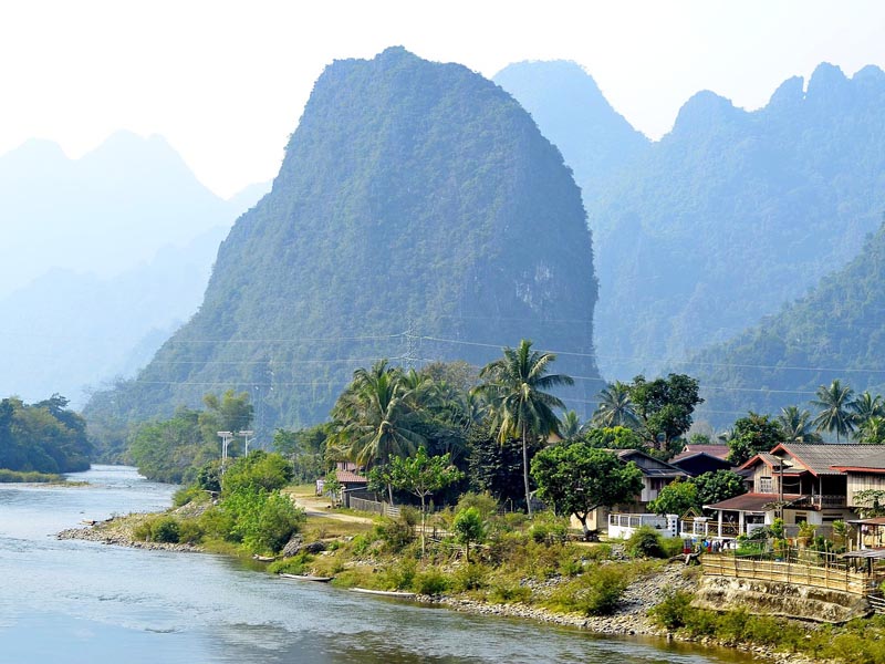 Limestone karst mountains rising above Mekong River village outside Luang Prabang Laos