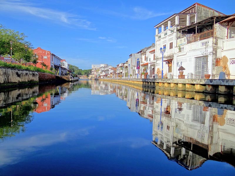 Morning reflections along the Melaka River framed by restored shophouses in the city’s UNESCO heritage district
