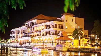 Riverside view of Casa del Rio Melaka with warm evening lights reflecting over the Malacca River promenade