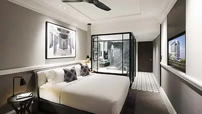 Contemporary guest room at Grand Park City Hall Singapore featuring modern décor, glass-enclosed bathroom, and city-center luxury accommodation
