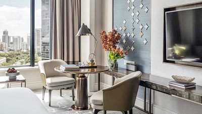 Refined guest room at Four Seasons Hotel Singapore with modern furnishings, city skyline views, and a calm, upscale ambiance.