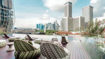 Rooftop infinity pool at Naumi Hotel Singapore overlooking the Marina Bay skyline and central business district skyscrapers